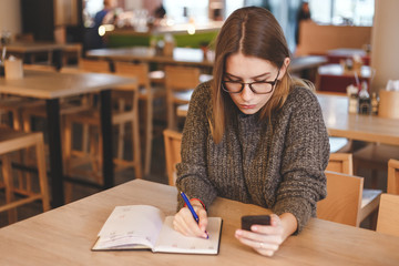 Stylish attractive young businesswoman working in the cafe