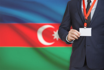 Businessman holding name card badge on a lanyard with a national flag on background - Azerbaijan
