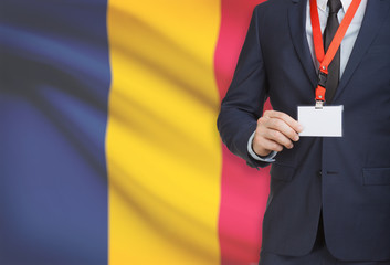Businessman holding name card badge on a lanyard with a national flag on background - Chad