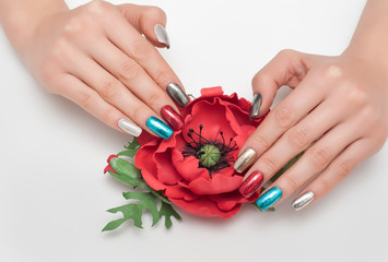 New Year's manicure on long square nails red, blue, black, gold, silver with a flower in the hands