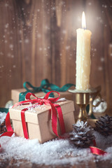 Gifts and candle on wooden background