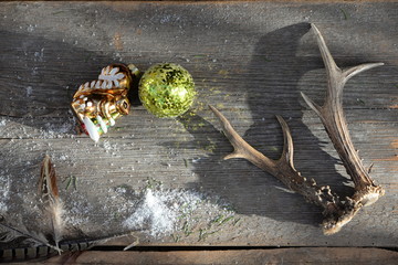 Jägerweihnacht, Weihnachtsdeko auf Holzbrett mit Federn, Abwurfstangen und Baumschmuck