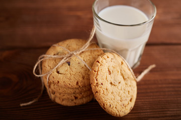 Cookies and milk. Chocolate chip cookies and a glass of milk. Vintage look. Tasty cookies and glass of milk on rustic wooden background. Food, junk-food, culinary, baking and eating concept