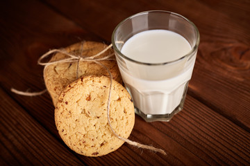 Cookies and milk. Chocolate chip cookies and a glass of milk. Vintage look. Tasty cookies and glass of milk on rustic wooden background. Food, junk-food, culinary, baking and eating concept