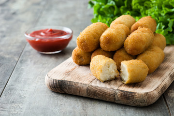 Traditional fried Spanish croquetas (croquettes) on wooden background
