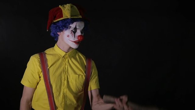 Terrifying clown with an axe frightening you. HD.