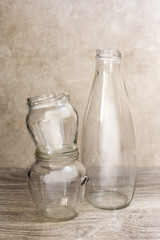empty glass bottle and jars over wood