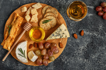 Assortment of cheese with wine, honey, nuts and grape