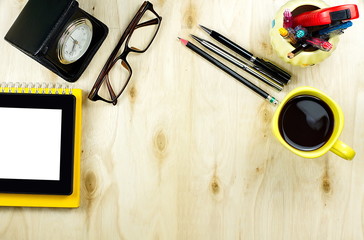Tablet PC with blank screen on yellow notebook with cup of coffe