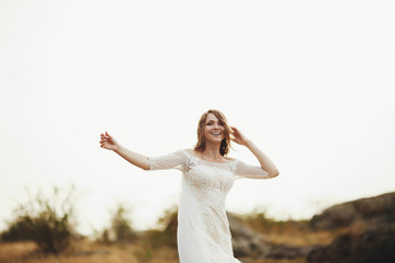 Fototapeta na wymiar beautiful bride in a white dress walking on the field