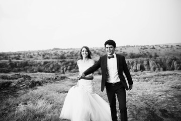 Fototapeta na wymiar beautiful and happy groom and bride walking outdoors
