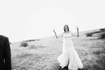 beautiful bride in a white dress walking on the field