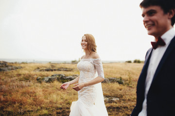 Fototapeta na wymiar beautiful and happy groom and bride walking outdoors