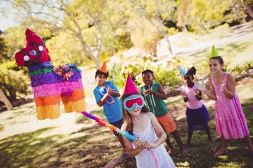 Little girl is going to broke the pinata for their birthday