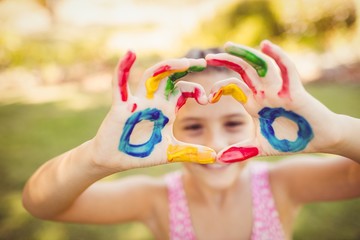 Girl making a heart with her painted arms