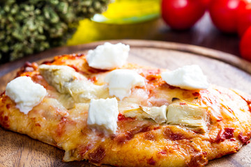 pizza with artichoke and oregan on wood