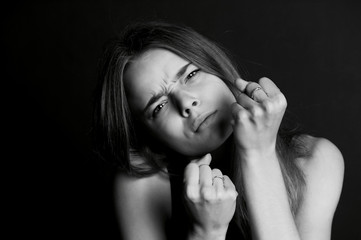 Hostile posture. Clenched fists before her face. Young beautiful girl with long hair