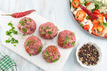 Raw meatballs ready for frying on a tray