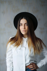 Portrait of young sexy girl in black hat and white shirt 