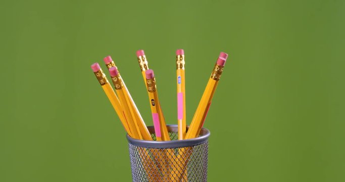 Yellow eraser pencils turning on a green background.