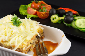Lasagna portion served with fresh vegetables
