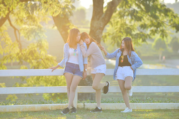 Three asian young ladys enjoy afternoon heat in garden .