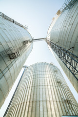 Huge, silver, shining agricultural silos. © eunikas