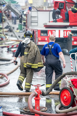 Fototapeta na wymiar fire fighter and rescuer walking away building in the drops of water after putting out the
