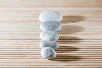 Fototapeta na wymiar Sea stones on bamboo background. Row pebbles.