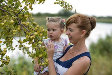 Mom shows daughter berries on the tree