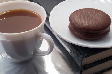 White cup of hot chocolate and a biscuit covered with chocolate
