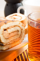 Glass mug with hot tea and chocolate cake for breakfast