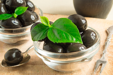 Brown pickled olives in a transparent cups