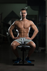 Fototapeta na wymiar Nerd Man After Exercise Resting In Gym