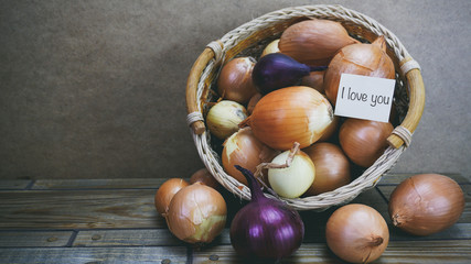 Onions in a wooden basket, word on paper