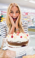 Happy woman with mouth open in front of cake