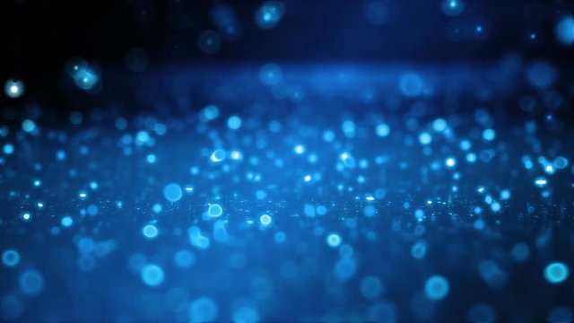 Soft-focused blue particles falling and bouncing on the glossy surface. FullHD 1080p.