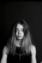 Naklejka premium Young beautiful girl builds faces. Hamming , fun