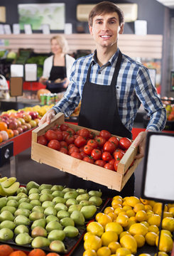 Happy Employee Of Farm Food Store With Fruits