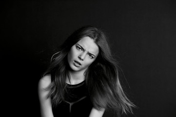 Fototapeta premium A young girl with long hair. Daring look in . BW