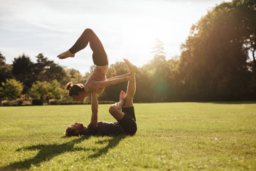 Strong young couple doing acroyoga workout