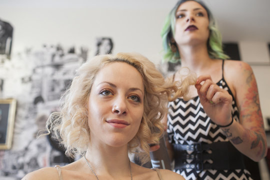 Female hair dresser styling customer's hair in salon