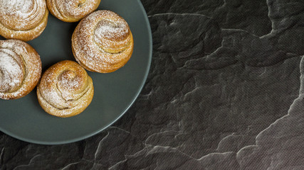 Homemade pastries cruffins, muffin with sugar powder, on dark background, selective focuse close up, copy space