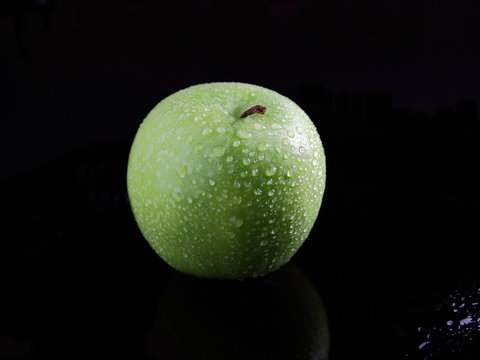 зеленое яблоко в каплях воды
