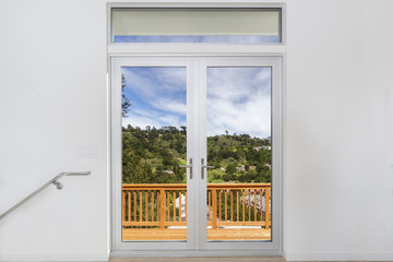 Aluminum door with double glass window and wooden deck.