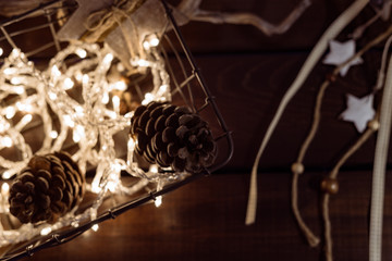 A basket filled with christmas lights and pine cones for decoration on a table. Top view