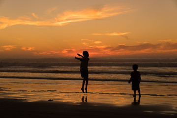 Fototapeta premium Children Playing in the Surf at Sunset, Pismo Beach California