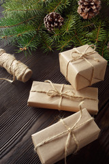 Christmas composition on wooden background with tree, pine cones and cardboard boxes