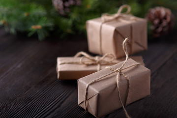 Christmas composition on wooden background with tree, pine cones and cardboard boxes