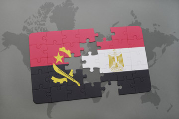 puzzle with the national flag of angola and egypt on a world map.